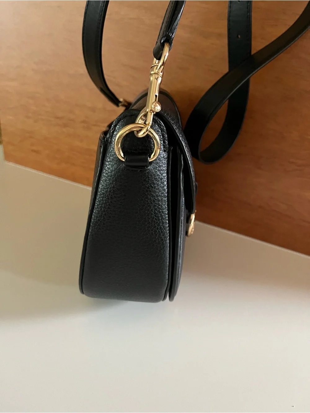 Coach Georgie crossbody saddle bag in black pebbled leather, gold tone hardware